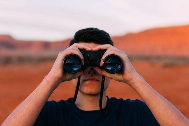 Man peeking through binoculars