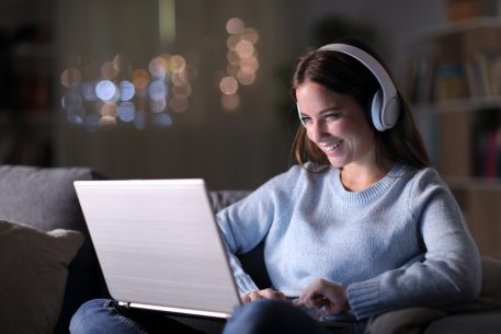 Young woman at laptop smiling at amazing Thinkific examples
