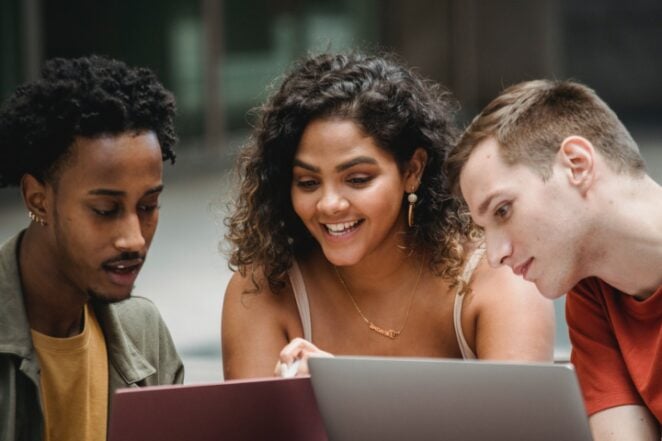 Three people at laptop looking up digital product ideas