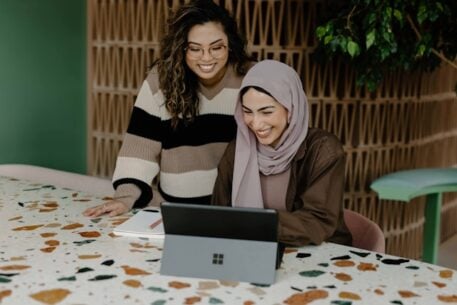 Two young women looking at course platforms on a laptop